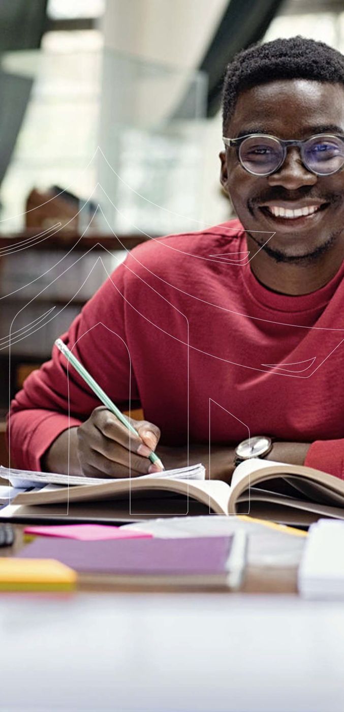 Étudiant souriant qui révise à son bureau